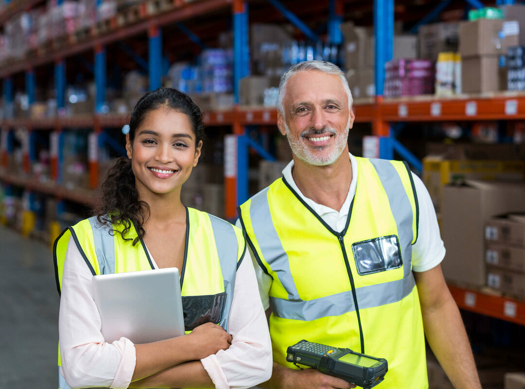 2 Menschen vor einem Regal in einem Lagerhaus.