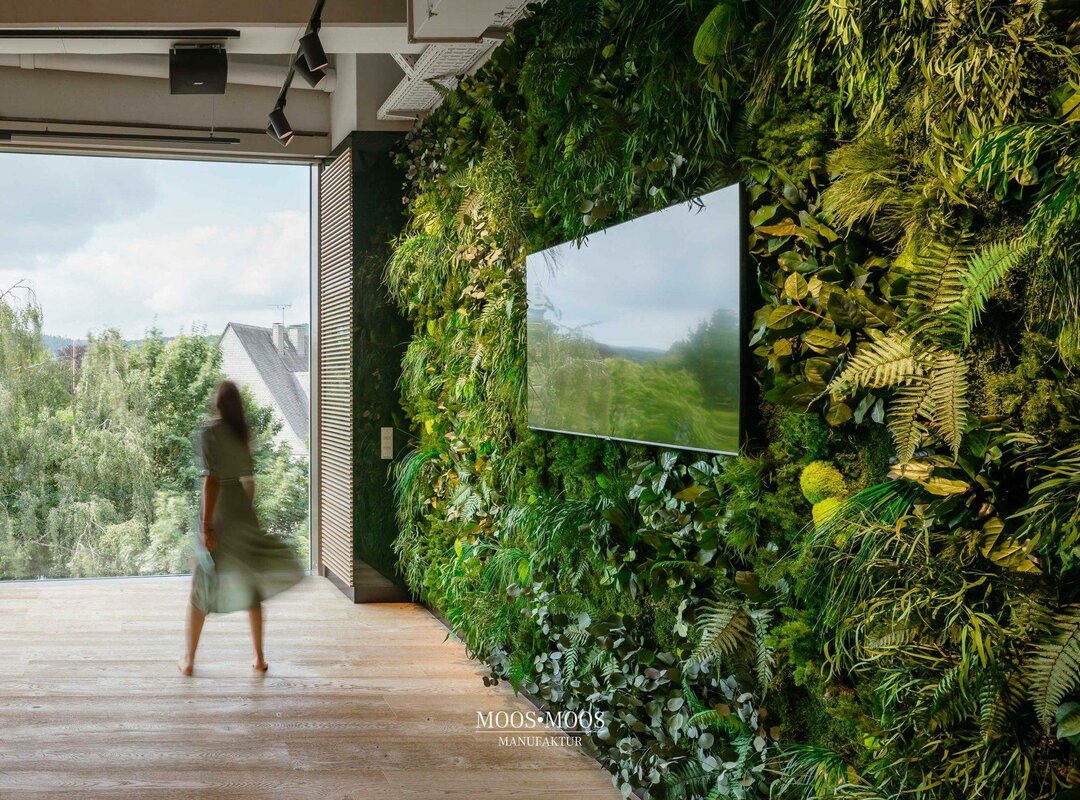 Eine Frau läuft an einer Wand mit Moos vorbei.