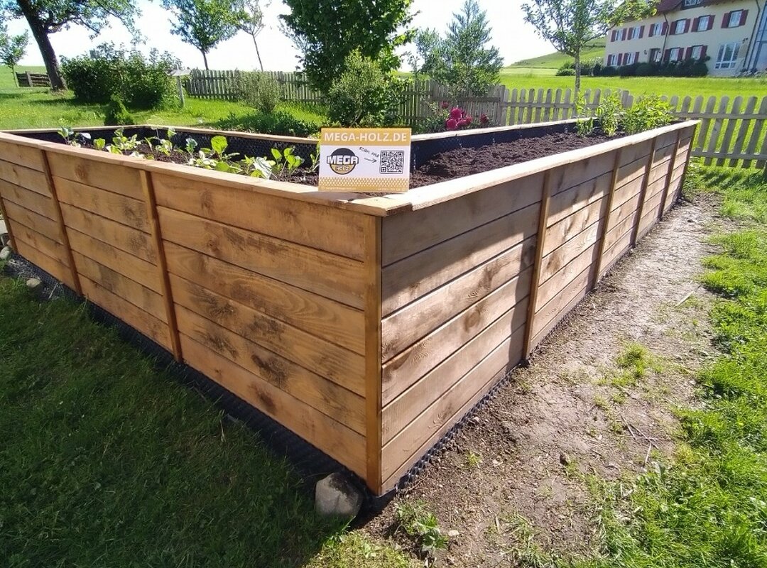 Ein Hochbeet mit der Anzeige für mega-holz.de.