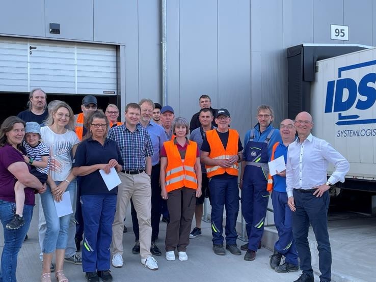 Leute stehen auf Platz vor Gebäude