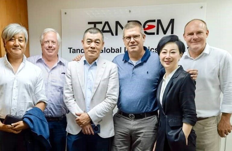 Eine kleine Gruppe an Menschen, die nebeneinander für das Foto posen.