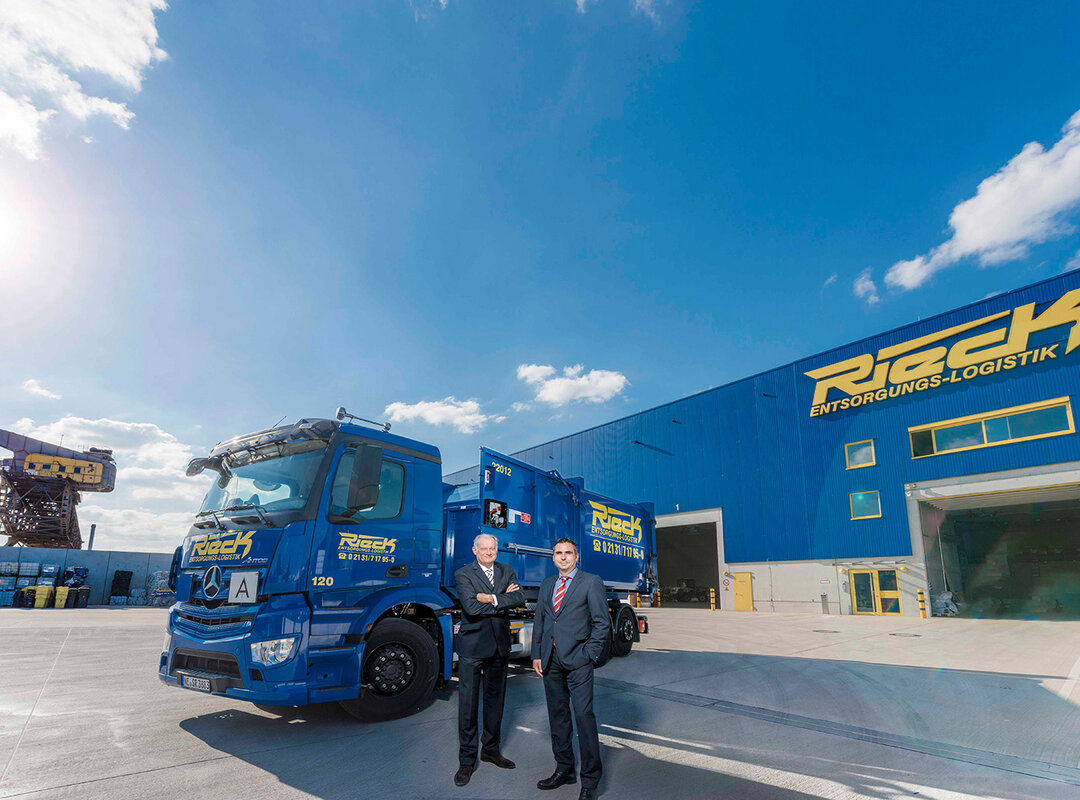 2 Männer vor einem Lkw vor dem Rieck Gebäude.
